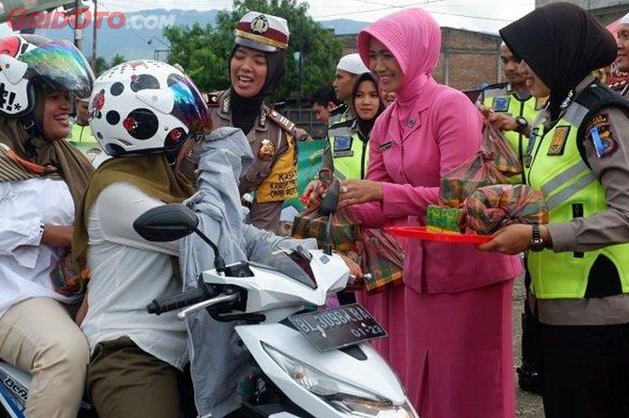 Kasat Lantas AKP Vifa didampingi Ketua Bhayangkari Cabang Aceh Besar memberikan takjil kepada pengguna jalan di Jalan Banda Aceh-Medan, Simpang Aneuk Galong, Besar, Selasa (28/5/2019).