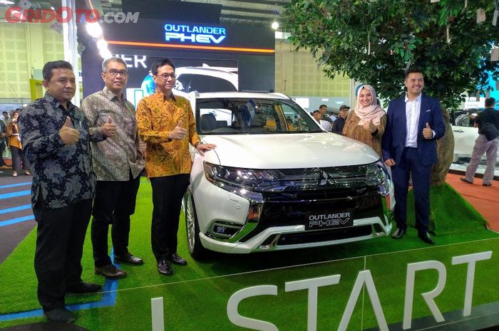 Jajaran PT MMKSI berfoto di depan Outlander PHEV dan wish tree di booth Mitsubishi di IEMS 2019.