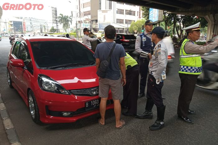 Honda Jazz berkelir merah yang terkena tilang di perluasan ganjil genap Fatmawati, Jakarta Selatan.