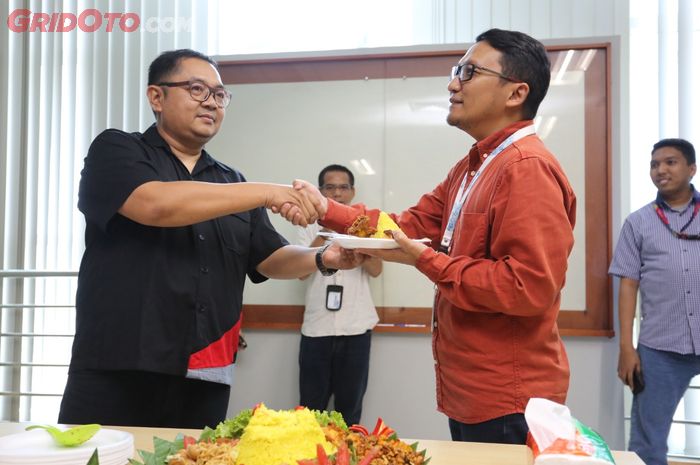  Billy Riestianto (Kiri) selaku  General Manager Otomotif Group memberikan potongan tumpeng pertama kepada Harry Kristianto (Kanan) selaku Deputy Group Director,  dalam acara syukuran ulang tahun GridOto.com.