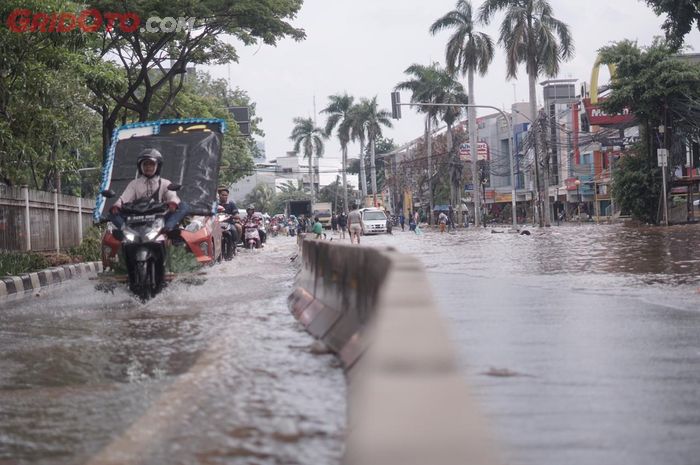 Genangan air banjir terjadi setelah hujan lebat di berbagai wilayah di Indonesia.  Bikers yang Terpaksa Beraktivitas di Luar Rumah, BMKG Prediksi Hujan Lebat Disertai Angin Hari Ini (7/4/2020).
