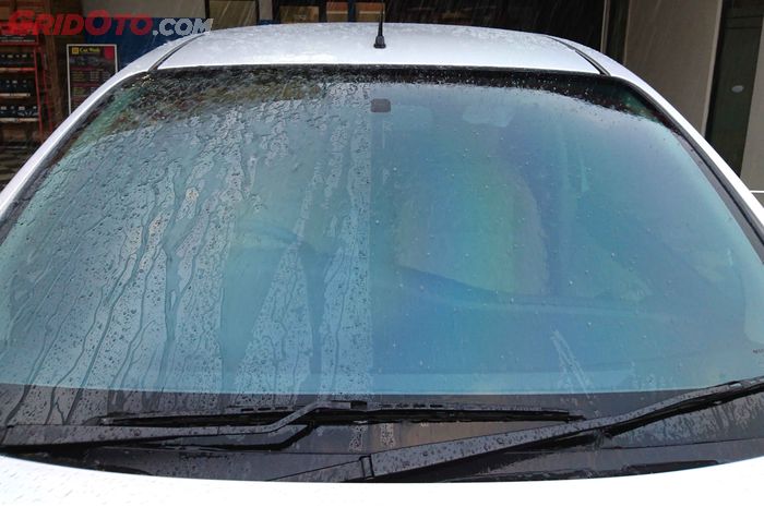 Ilustrasi aplikasi rain repellent di kaca depan mobil