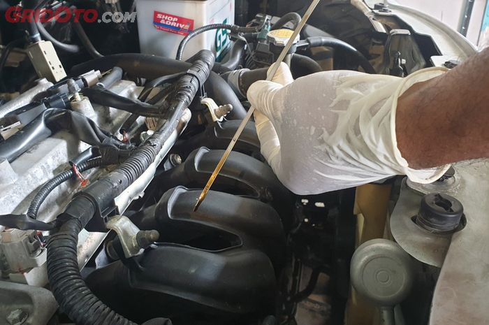 Ilustrasi cek oli mesin mobil dengan dip stick