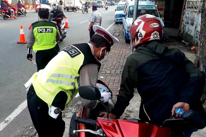 Polisi membantu mengecek kartu identitas dan SIKM