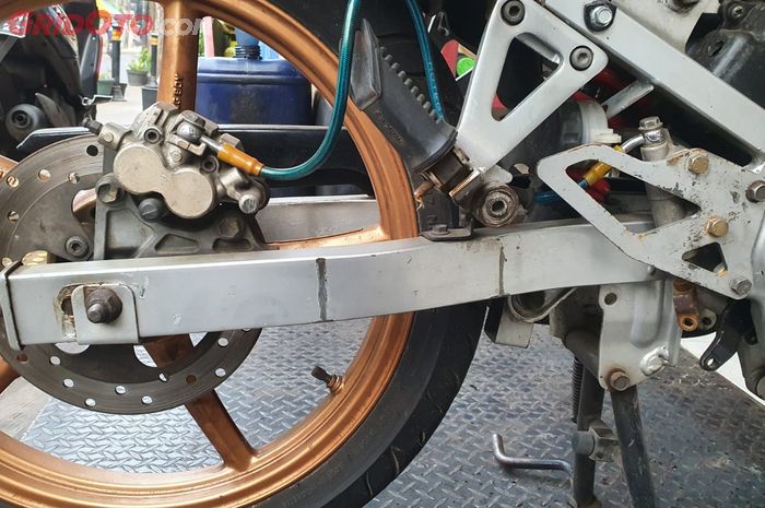 Standar tengah terikat dengan swing arm di motor Suzuki Satria 120