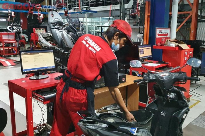 Ilustrasi servis motor di bengkel resmi