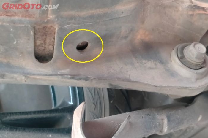 Lobang kecil di bagian bawah knalpot motor.