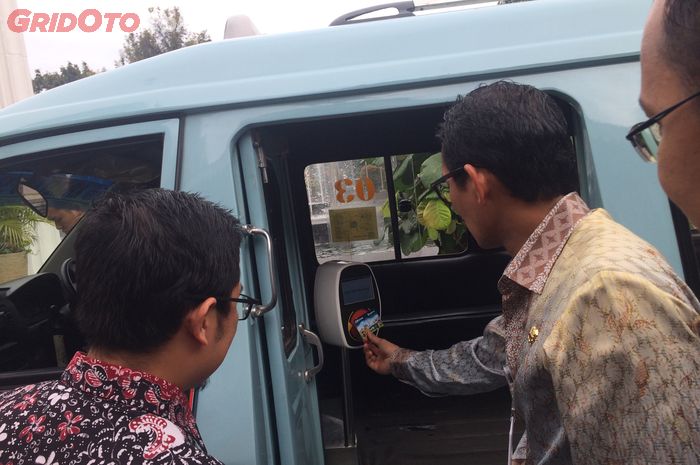 Wagub DKI Jakarta Sandiaga Uno mengetapkan kartu Ok Otrip di mesin tap angkot