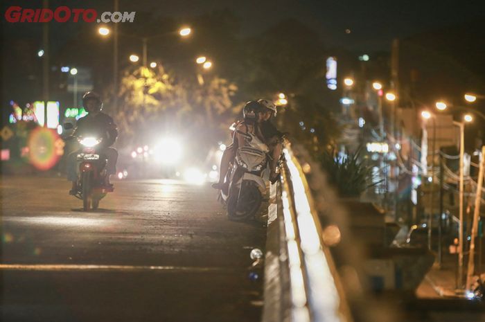 Ilustrasi pengendara motor yang berhenti di jembatan atau flyover