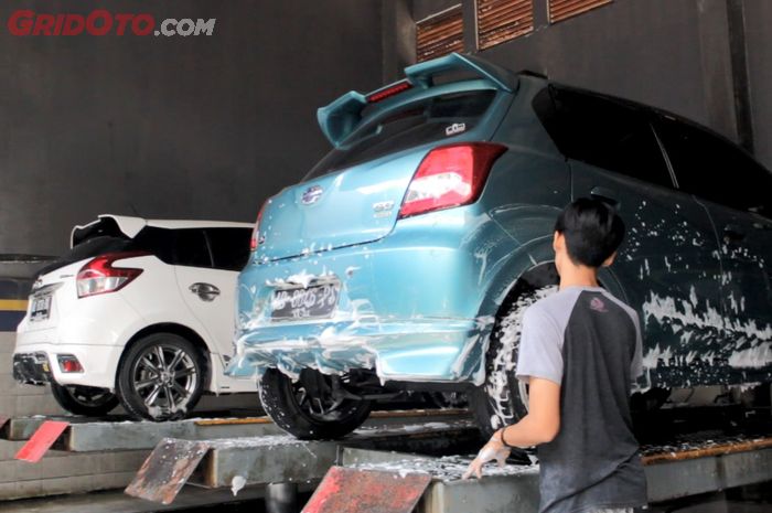 Cuci mobil di bawah terik matahari langsung, awas cat mobil cepat rusak. Ilustrasi cuci mobil dengan diangkat lifter