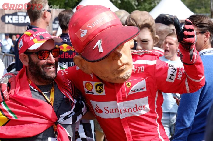 Salah satu penonton yang berfoto dengan maskot pembalap idolanya, kimi Raikkonen