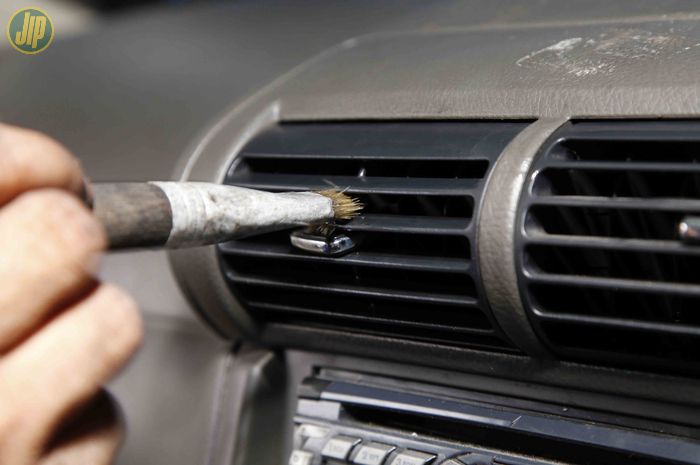 Ilustrasi membersihkan kisi-kisi AC mobil