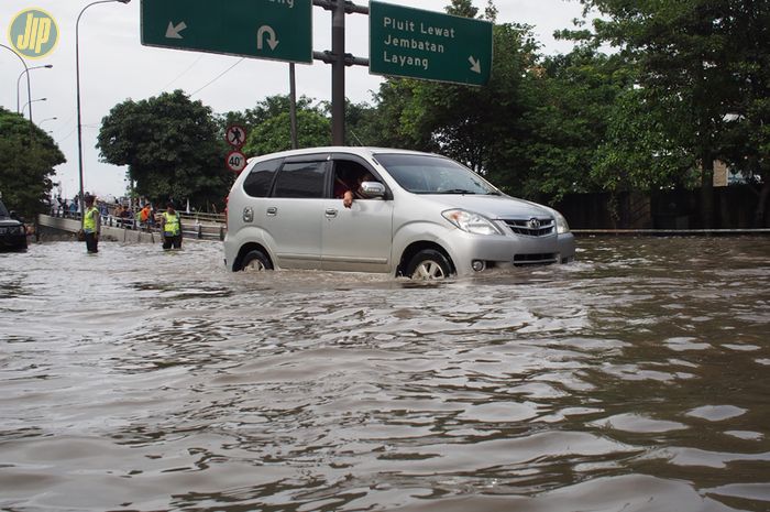 Ilustrasi mobil melewati banjir