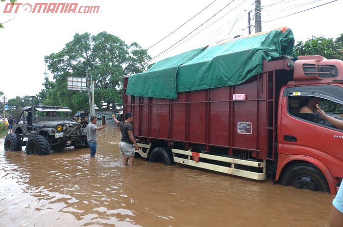 Jeep yang sama masih kuat menarik sebuat truk dari pool yang terendam banjir.