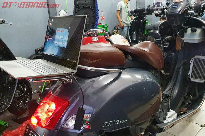 Ilustrasi proses remap ECU Vespa matic, pakai laptop dengan koneksi bluetooth