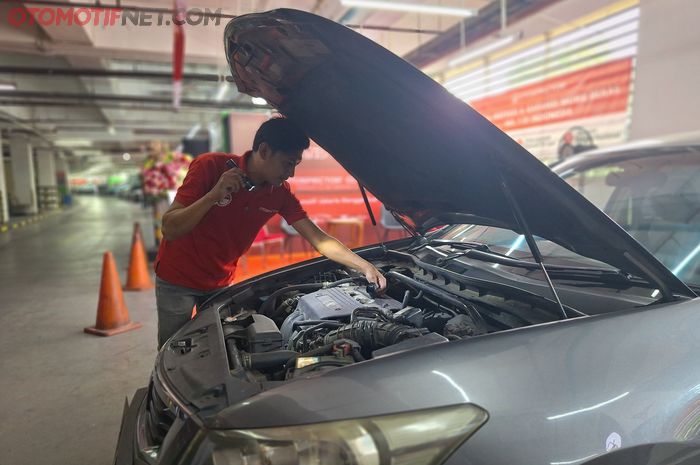 Inspector mobil dari Otospector sedang mengecek mobil milik customer