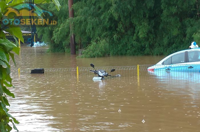 Satu unit Honda Supra X 125 terlihat terendam banjir, begitu pun dengan mobil taksi Bluebird berjenis Toyota Limo.