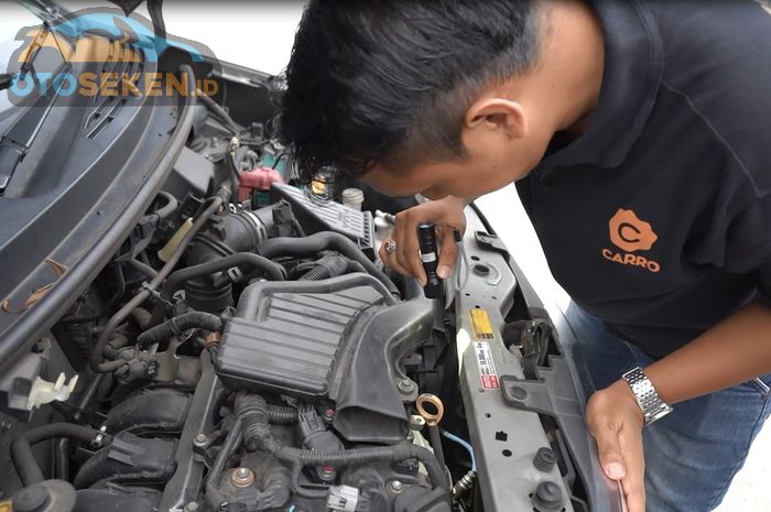 Mengecek mobil bekas tabrak