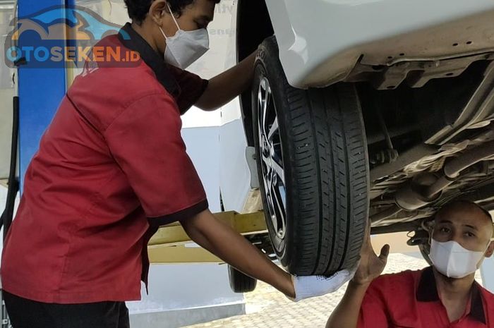 Untuk pengecekan ball joint, goyangkan roda ke atas dan ke bawah