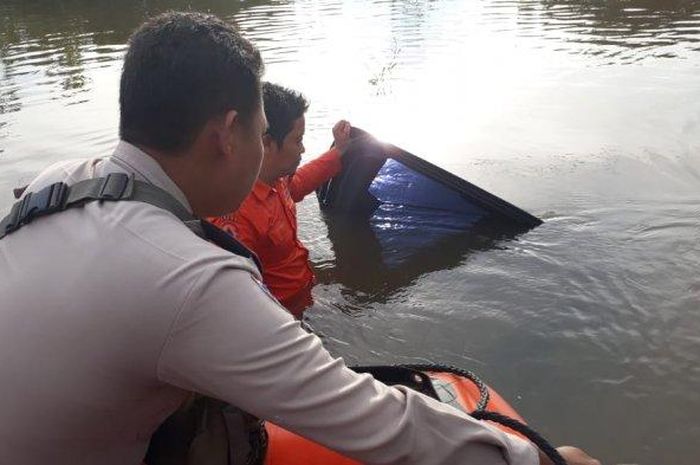 Pihak kepolisian dan warga evakuasi mobil tenggelam di Jalan AMD Muara Bulian, Rabu (12/12/2018)