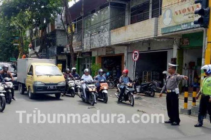 Satlantas Polres Pamekasan mengatur lalu lintas agar tak berhenti di traffic light, (17/12/2018)