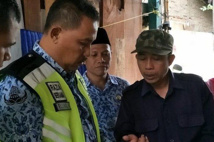 Andi (53) bersama Kepala Unit PKB dan Bea Balik Nama Kendaraan Bermotor (BBNKB) &lrm;Jakarta Barat, Elling Hartono di rumahnya Jalan Karya Baru, RT 9/3, Grogol Petamburan, Jakarta Barat, Rabu (26/12/2018). 