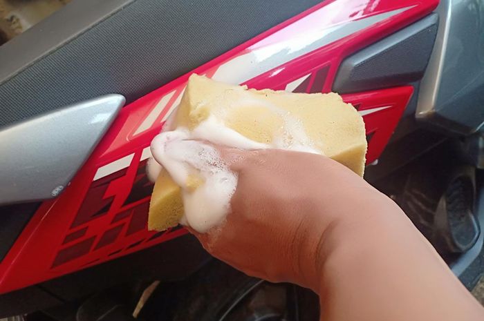 Ilustrasi mencuci motor dengan spons