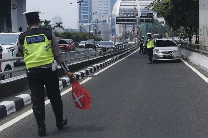 Petugas Ditlantas Polda Metro Jaya memberhentikan mobil berpelat nomor genap yang memasuki Jalan Gatot Soebroto, Jakarta, Rabu (1/8/2018). Petugas kepolisian mulai memberlakukan penindakan berupa tilang terhadap pengendara mobil yang melanggar di kawasan perluasan sistem ganjil-genap.(ANTARA FOTO/HAFIDZ MUBARAK A) 