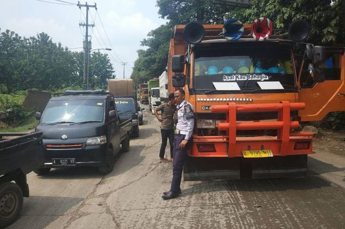 Petugas Dishub Kab. Tangerang menerapkan buka-tutup arus di Jalan Raya Parung untuk menghindari penumpukan kendaraan, Rabu (9/1/2019).(KOMPAS.com/ ANANDITA GETAR REZHA)