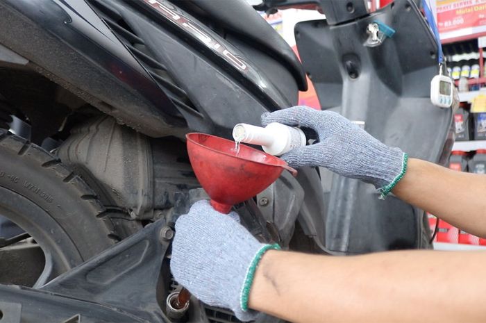 Ilustrasi servis dan ganti oli motor matic