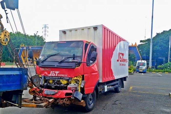 Truk boks ekspedisi barang dievaluasi mobil derek seusai alami kecelakaan di Ruas Tol Jatingaleh-Krapyak Kota Semarang, Minggu (13/1/2019). 
