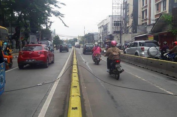 Kabel jaringan telepon sepanjang kurang lebih 20 meter melintang di Jalan Jatinegara Barat, tepatnya di depan Rusun Jatinegara Barat, Senin (14/1/2019). 