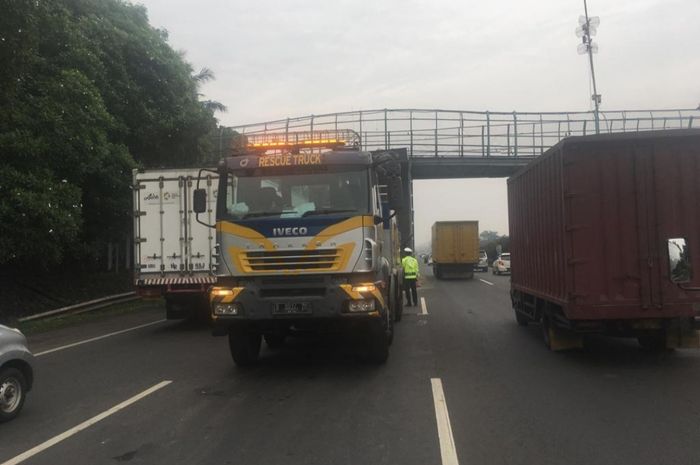 Sebuah truk penyelamat sedang melakukan penanganan insiden truk tersangkut JPO di Jalan Tol Jakarta-Tangerang