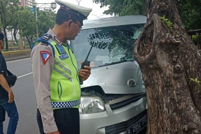 Seorang polisi lalu lintas saat berada di lokasi tertabraknya grand max pada pohon di Jalan Letjend Suprapto, Cempaka Putih, Jakarta Pusat pada Senin (14/1/2019) 