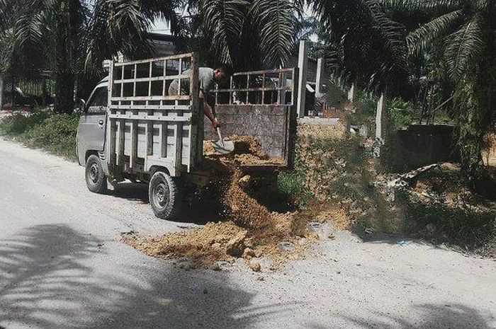 Wanhar Lingga memperbaiki jalanan rusak sendirian