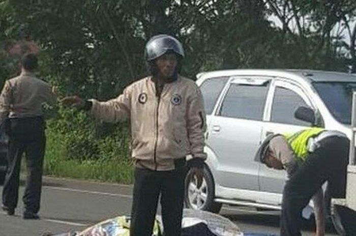Seorang anggota polisi dan warga mengatur lalu lintas di Jalan Raya Solo-Wonogiri usai terjadi lakala