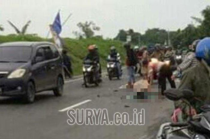 Kecelakaan maut yang melibatkan motor di depan SPBU Kudu, Jombang. Warga saat mengevakuasi korban