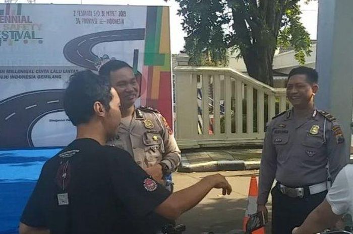 Warga mendengarkan sosialisasi yang dipimpin Kanit Regident Satlantas Polresta Solo, AKP Suryo Wibowo, di depan kantor Satlantas Jalan Slamet Riyadi, Minggu (10/2/2019). 