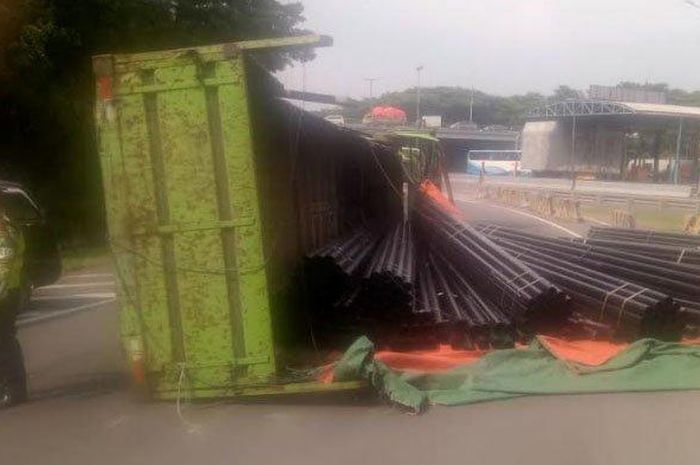 Muatan truk berupa pipa besi berserakan di jalan tol Sidoarjo, Rabu (13/2/2019).