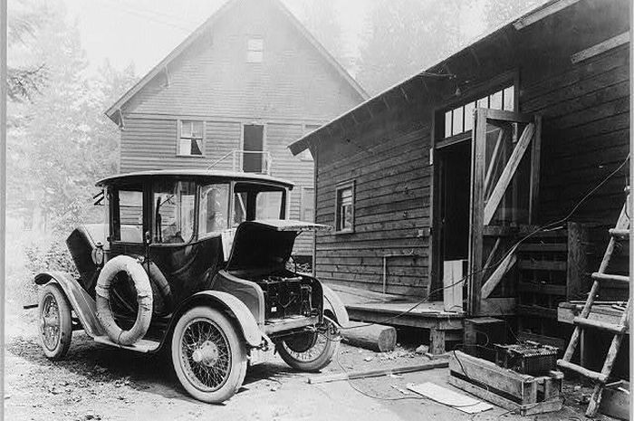 Ilustrasi pengisian baterai mobil listrik pada periode awal 1900-an