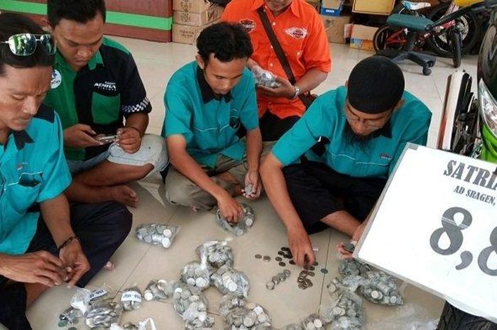 Uang receh yang dibayarkan pembeli, dihitung oleh pemilik dealer motor second (bekas) di Gebang Syariah Motor (GSM), Solo.