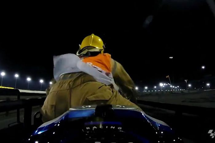 Aksi marshal menunggangi motor balap yang digendong di atas gerobak pengangkut menuju paddock