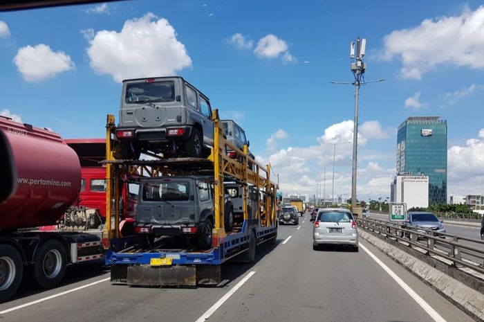 Beberapa unit Suzuki Jimny terbaru 2019 yang sedang diangkut oleh sebuah truk di jalanan. 