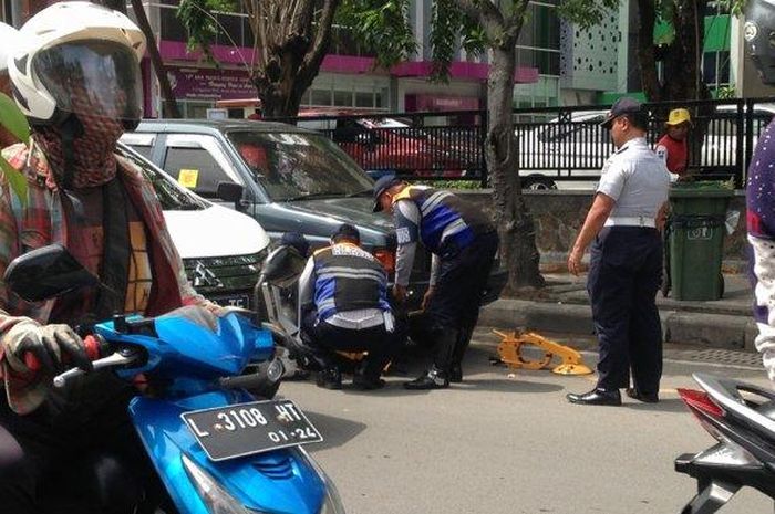 Petugas Dishub Kota Surabaya yang sedang menggembok mobil pelanggar parkir liar