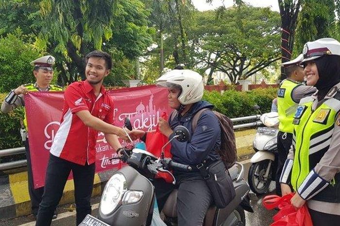 Kegiatan Bagi Takjil kepada para pengendara roda dua yang melintas di lampu merah siring Sabilal Muhtadin, Banjarmasin, Sabtu (25/5/2019)