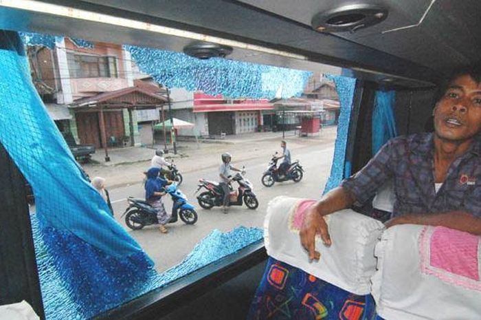 Ilustrasi dampak pelemparan kaca bus yang pecah dilempar batu.