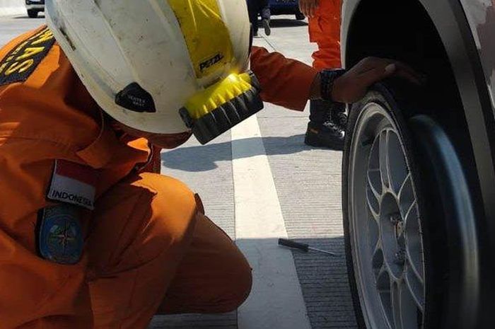 Petugas memeriksa kondisi roda belakang mobil Honda HR-V yang alami lepas ban di Tol Pandaan-Malang