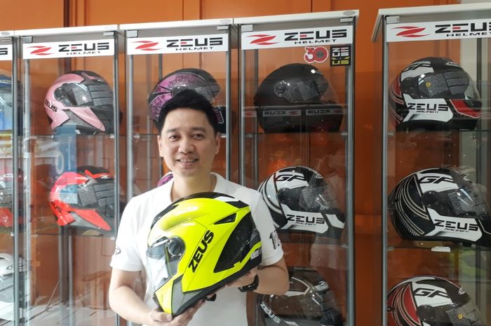 Agus Hermawan memegang salah satu Helm Zeus di outlet Juragan Helm miliknya.