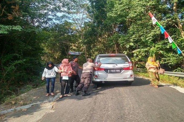 Sejumlah petugas polisi dan relawan membantu mendorong kendaraan yang tak kuat menanjak di Cinomati, Rabu (5/6/2019). 