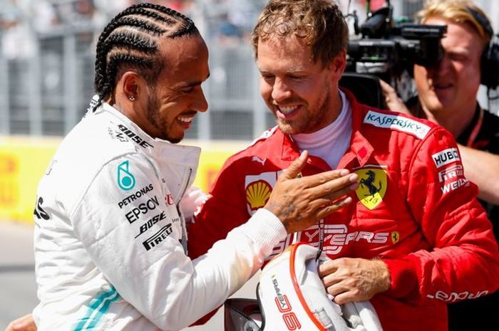 Lewis Hamilton (kiri) berusaha menghibur Sebastian Vettel usai insiden penalti yang ia terima di GP F1 Kanada. 